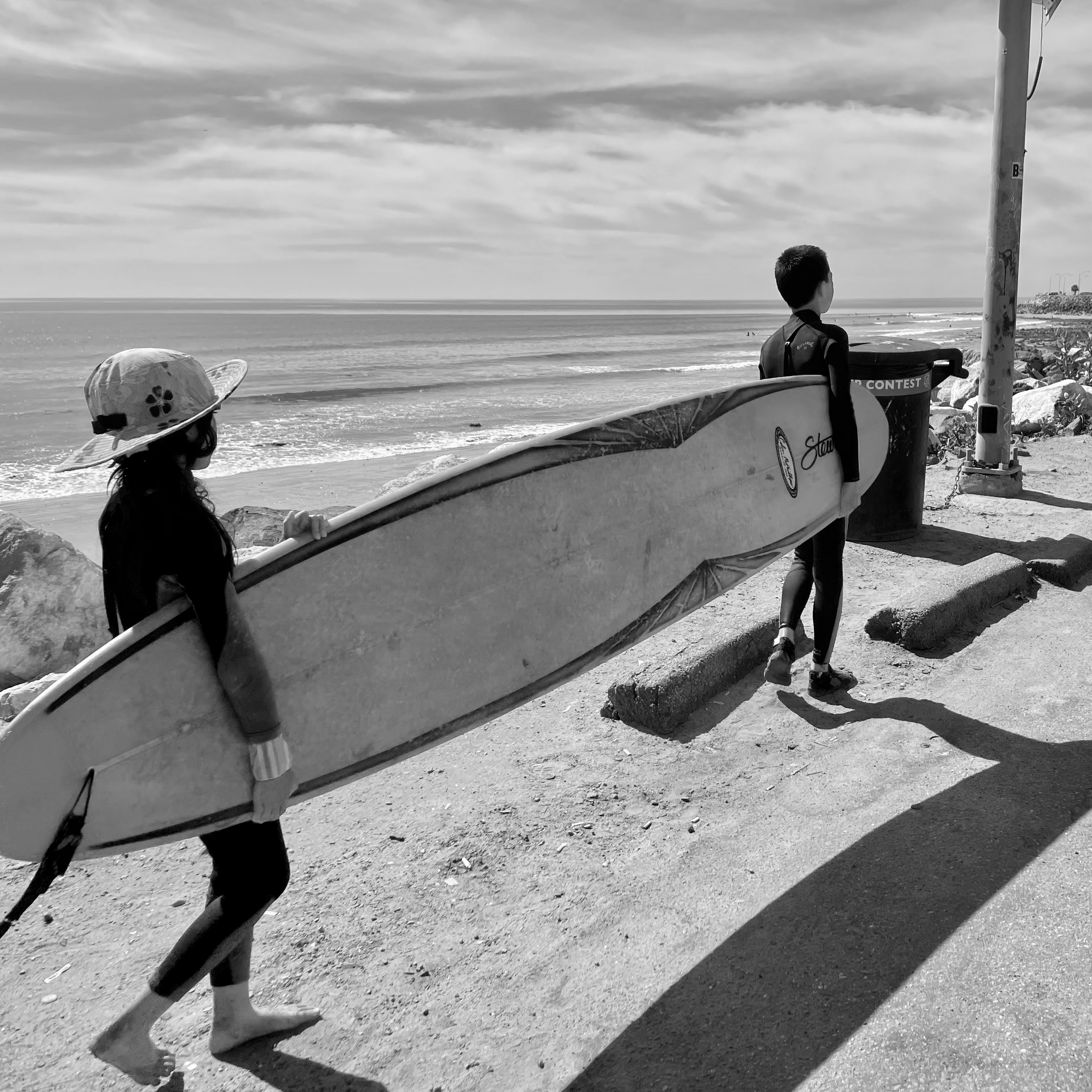 Kids working together to carry a surfboard